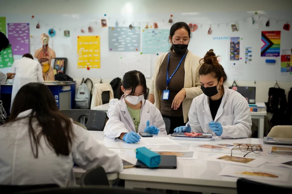 A teacher observes students working in a science class