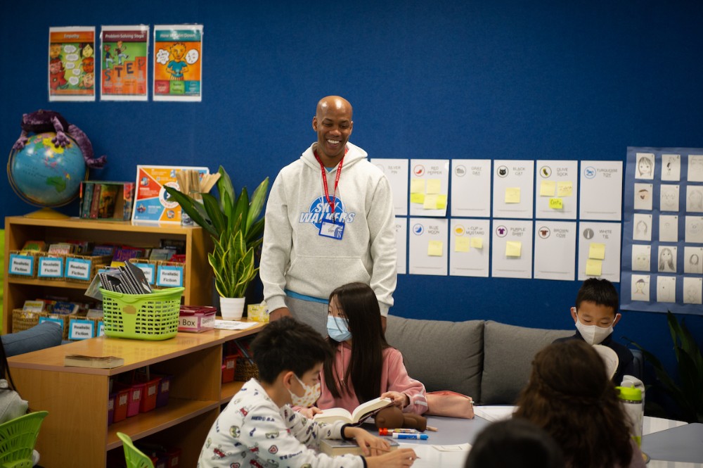 The basketballer Stephon Marbury smiles at the front of a classroom