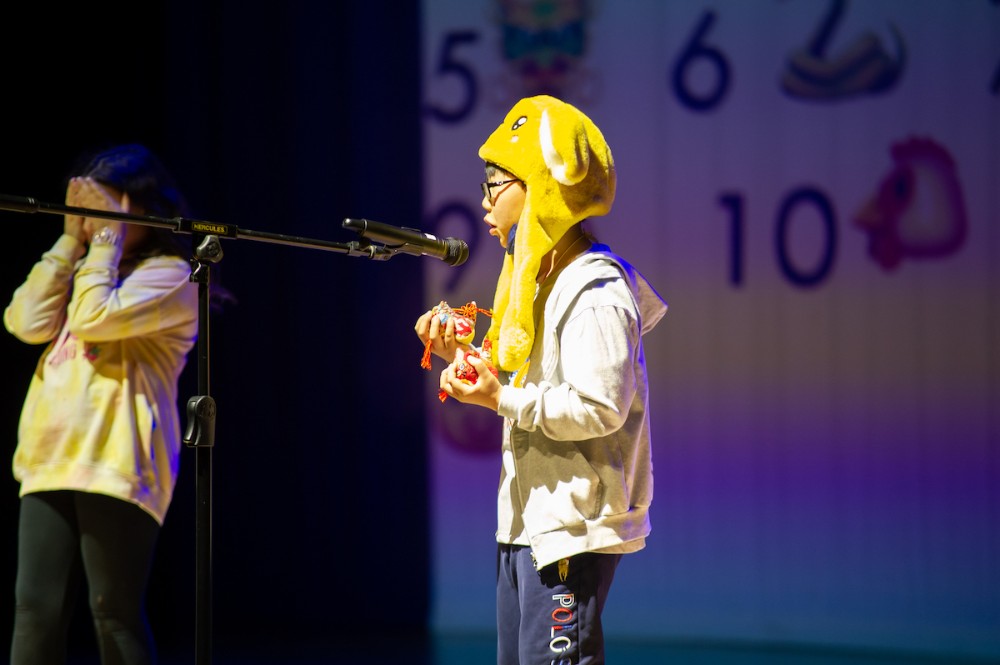 A student in a novelty hat performing on stage